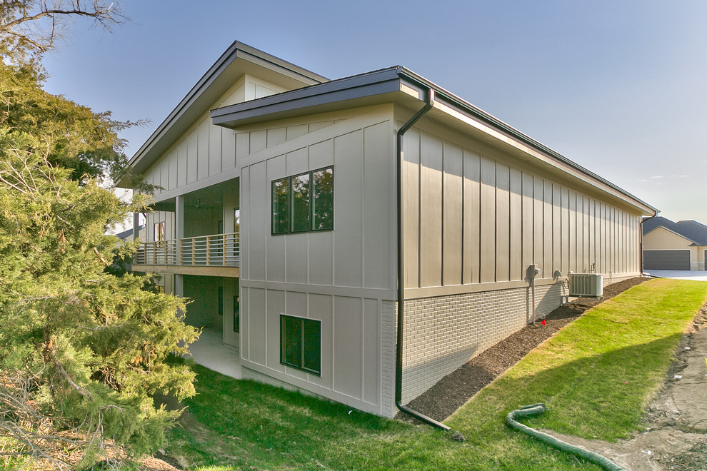 Cette image montre une façade de maison beige minimaliste de taille moyenne et de plain-pied avec un revêtement mixte et un toit en appentis.