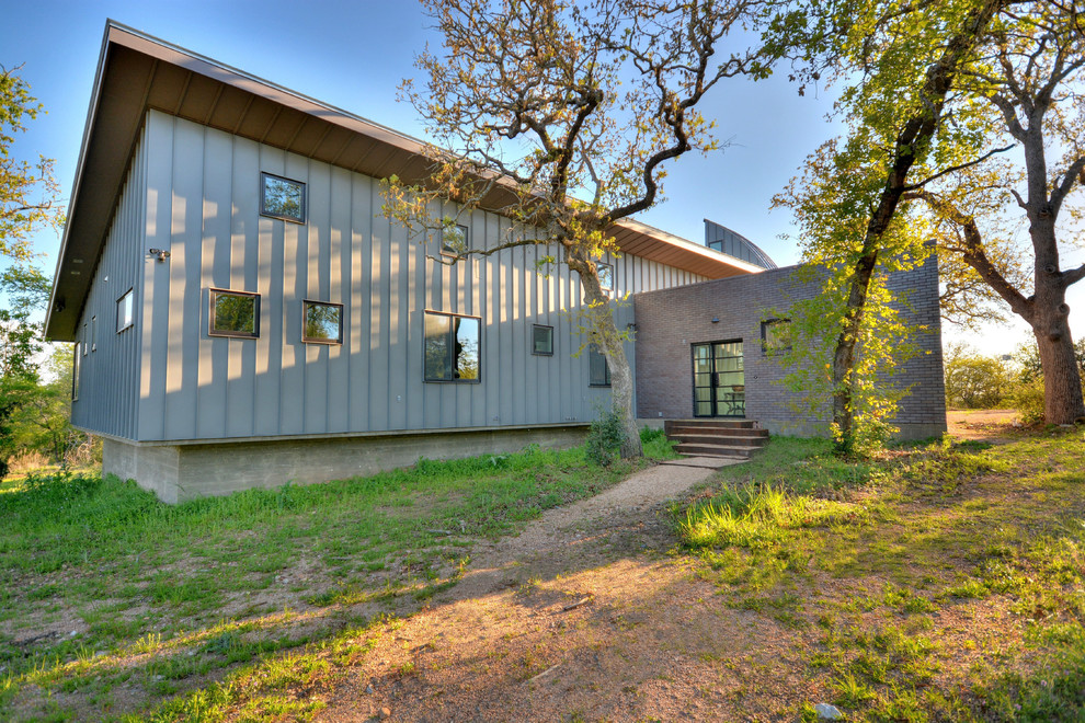 This is an example of a medium sized and gey modern bungalow house exterior in Austin with metal cladding.
