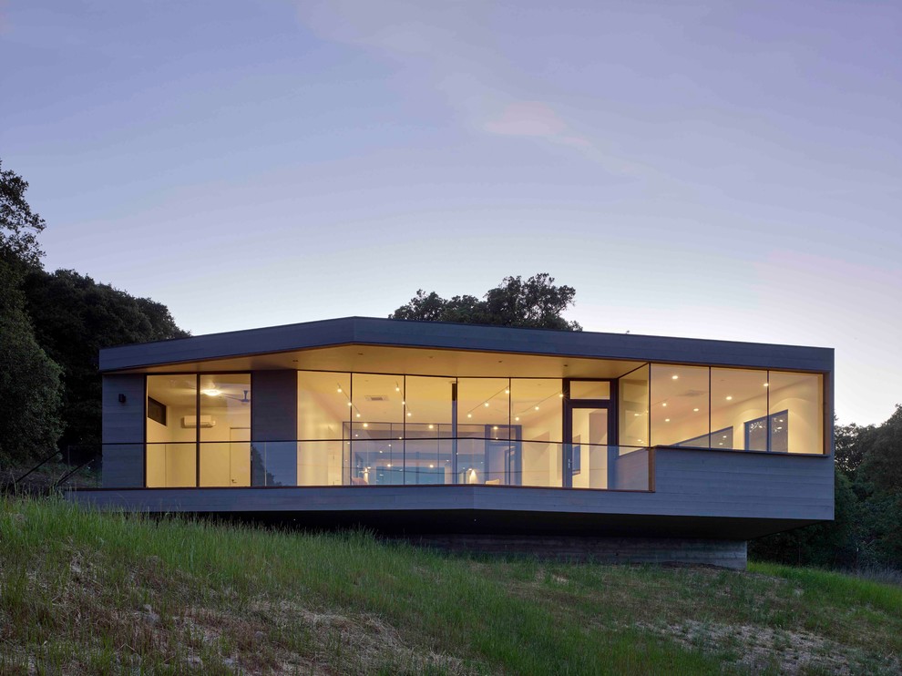 Modelo de fachada gris minimalista de tamaño medio de una planta con revestimiento de madera y tejado plano