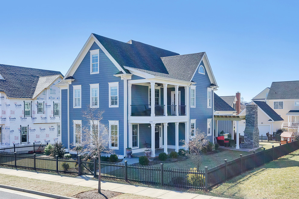 Ejemplo de fachada de casa azul de estilo americano grande de dos plantas con revestimientos combinados, tejado a dos aguas y tejado de teja de madera