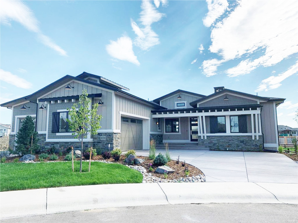 Zweistöckiges Country Einfamilienhaus mit Mix-Fassade, grauer Fassadenfarbe und Schindeldach in Denver