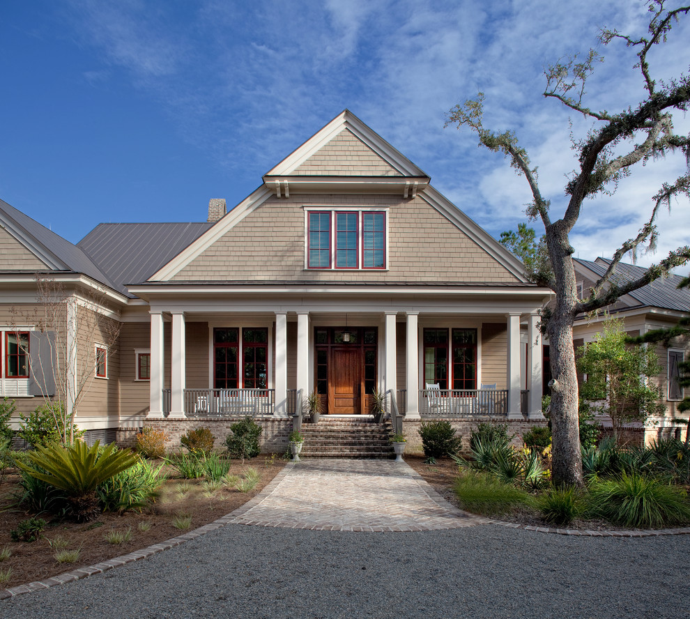 Стильный дизайн: большой, двухэтажный, бежевый дом в классическом стиле с комбинированной облицовкой и вальмовой крышей - последний тренд