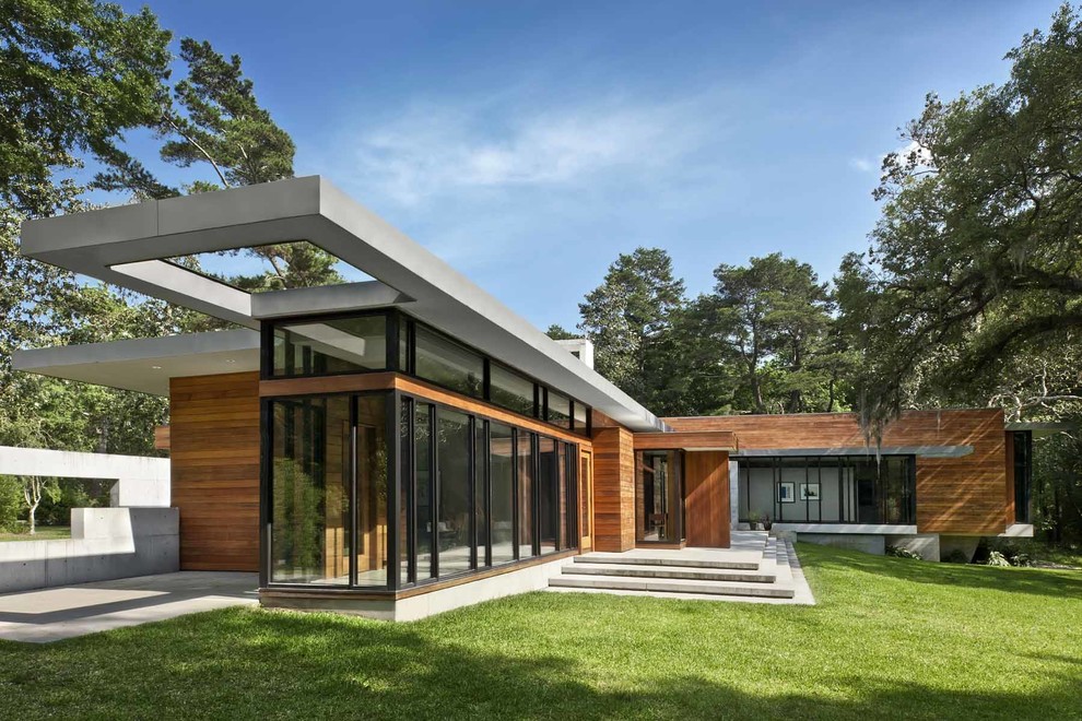 Diseño de fachada moderna grande de una planta con revestimiento de madera y tejado plano