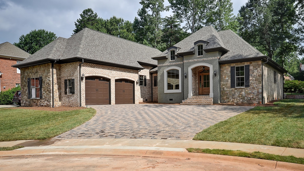 Photo of a large and beige mediterranean two floor brick house exterior in Other with a hip roof.