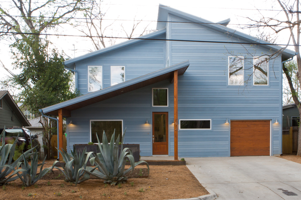 На фото: двухэтажный, синий дом среднего размера в стиле неоклассика (современная классика) с