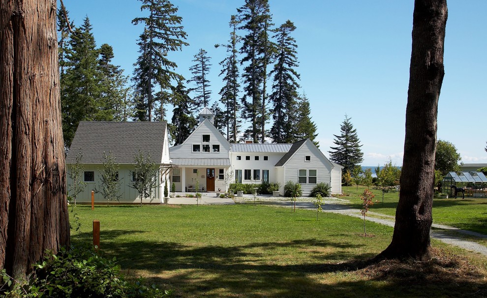 Diseño de fachada de casa blanca tradicional renovada de tamaño medio de dos plantas con revestimiento de madera, tejado a dos aguas y tejado de varios materiales
