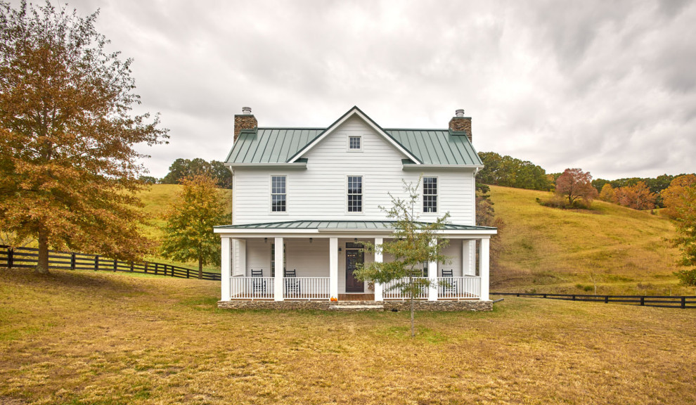 Imagen de fachada de casa blanca de estilo de casa de campo de tamaño medio de dos plantas con revestimientos combinados, tejado a dos aguas y tejado de metal