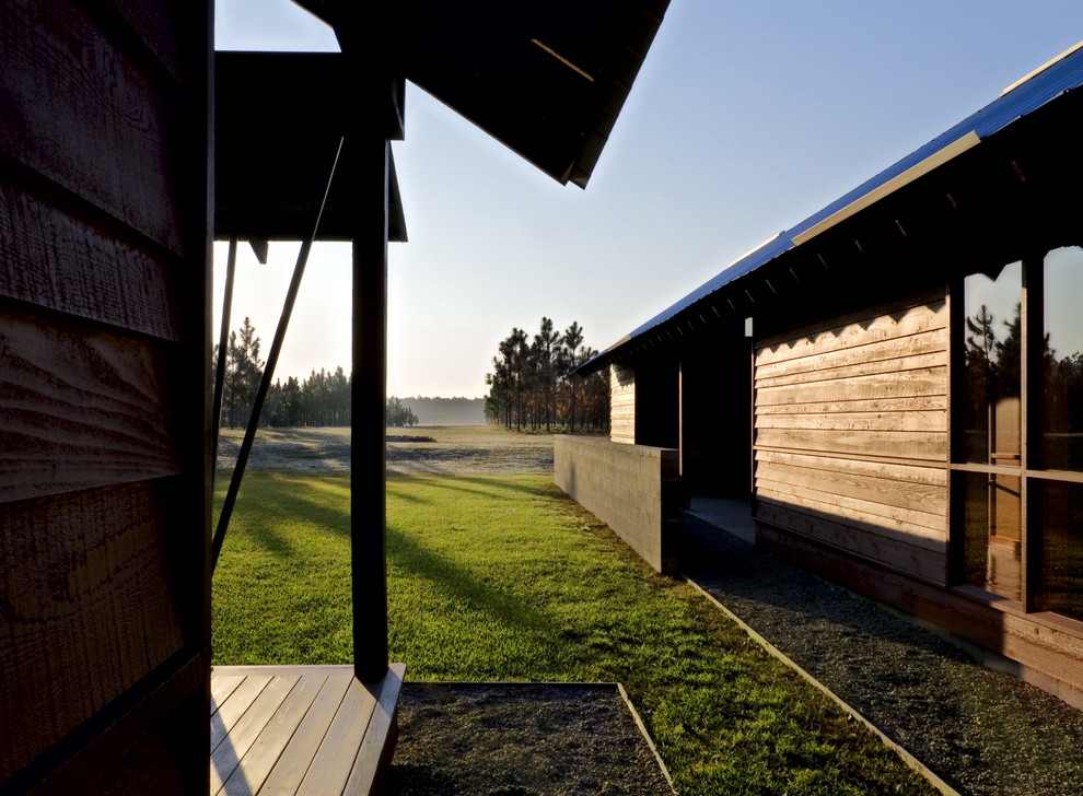 Foto de fachada roja rural extra grande con revestimiento de madera y tejado a dos aguas