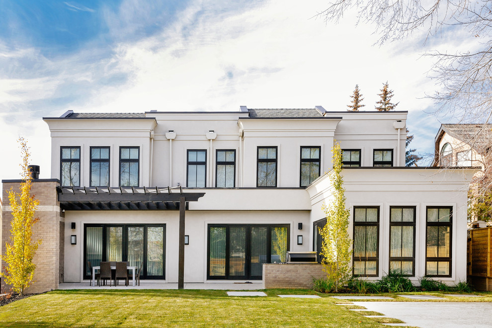 Modelo de fachada de casa blanca clásica renovada grande de dos plantas con revestimientos combinados, tejado plano y tejado de metal