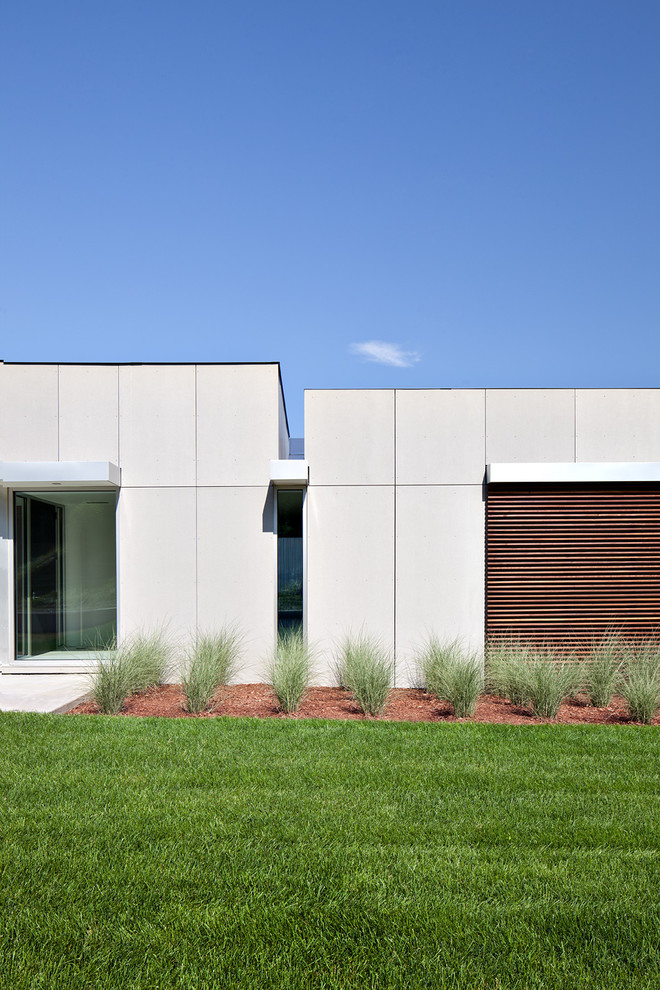 На фото: одноэтажный, серый дом в стиле модернизм с облицовкой из ЦСП с