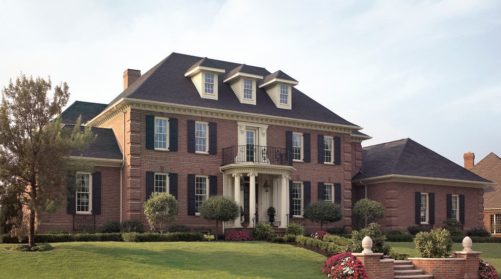 Large ornate red three-story brick exterior home photo in Other with a hip roof