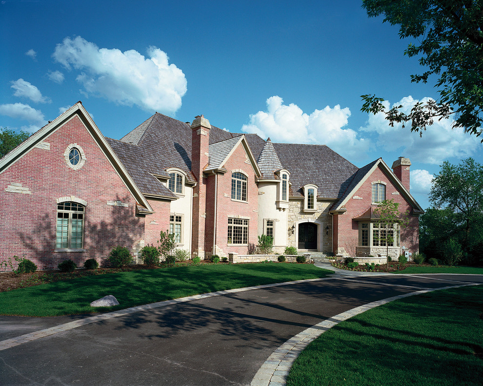 Immagine della villa ampia rossa classica a due piani con rivestimento in mattoni, tetto a capanna e copertura a scandole