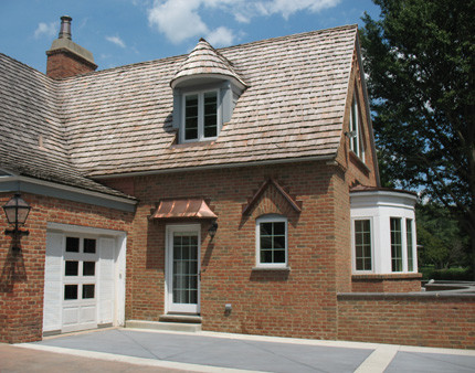 Idée de décoration pour une grande façade de maison marron tradition en brique à un étage avec un toit à deux pans.