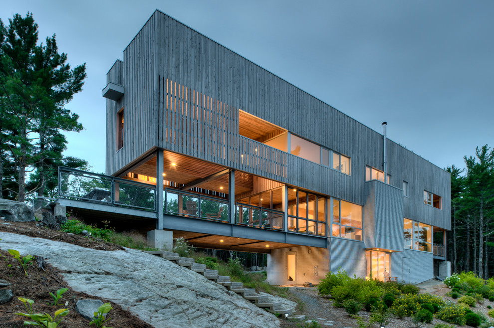 Imagen de fachada minimalista de tres plantas con revestimiento de madera, tejado plano y escaleras