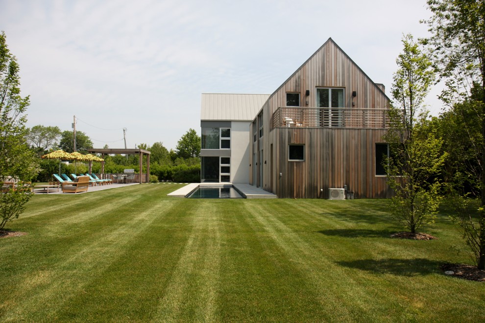 Immagine della facciata di una casa country con rivestimento in legno