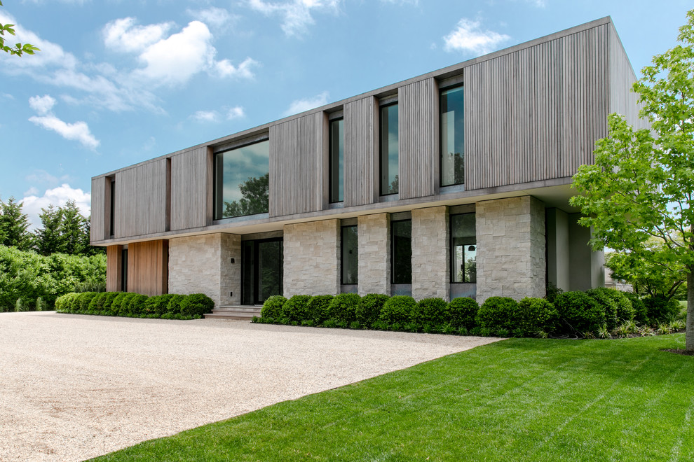 Foto della villa grande beige contemporanea a un piano con rivestimenti misti e tetto piano