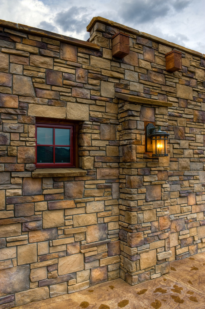 Photo of a rustic two floor house exterior in Denver with stone cladding.