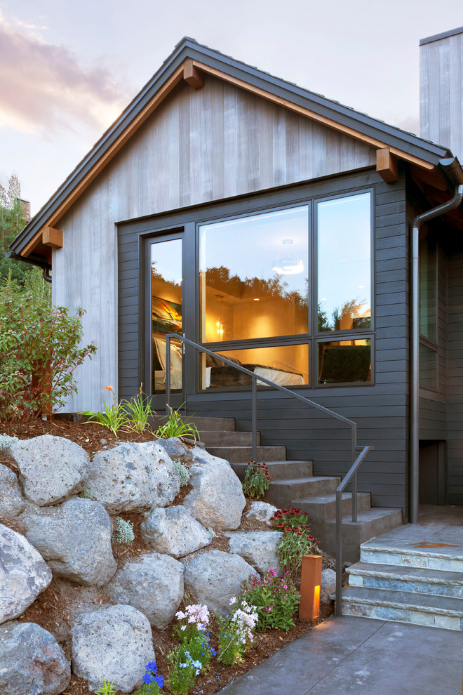 Стильный дизайн: большой, двухэтажный, деревянный, серый дом в современном стиле с двускатной крышей - последний тренд
