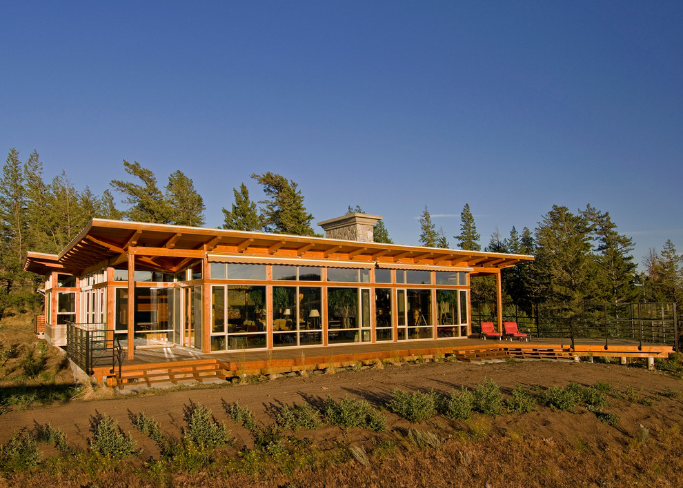 Cette photo montre une grande façade de maison marron montagne à un étage avec un revêtement mixte et un toit plat.