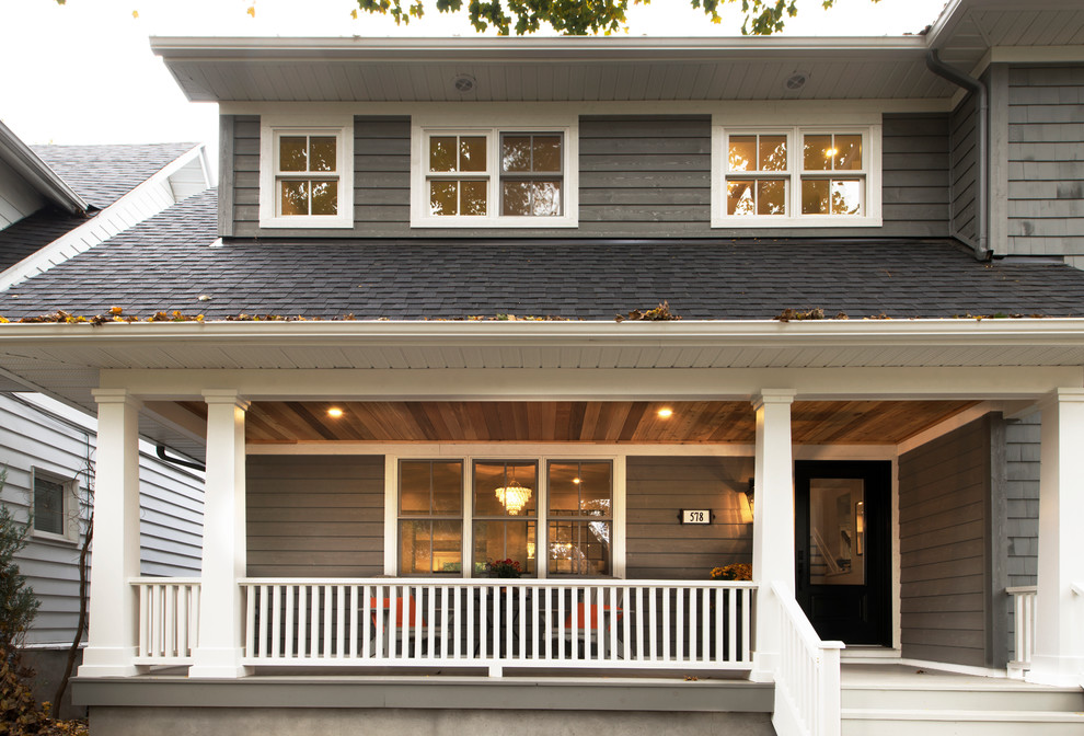 Cette image montre une façade de maison grise traditionnelle en bois de taille moyenne et à un étage avec un toit à deux pans.