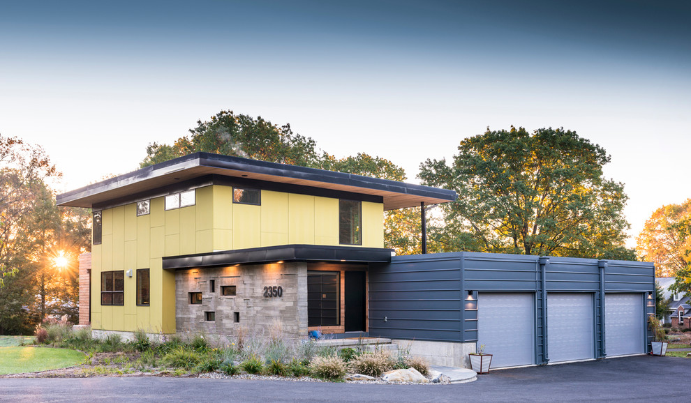 Large and yellow contemporary two floor house exterior in Philadelphia with mixed cladding and a flat roof.