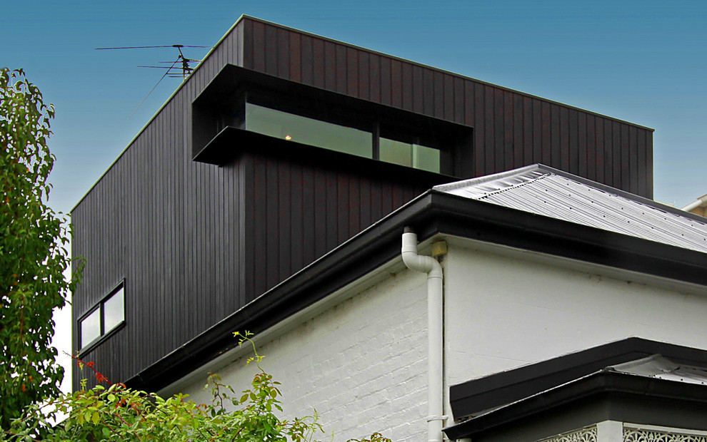 Mittelgroßes, Zweistöckiges Modernes Einfamilienhaus mit Backsteinfassade, weißer Fassadenfarbe, Walmdach und Blechdach in Melbourne