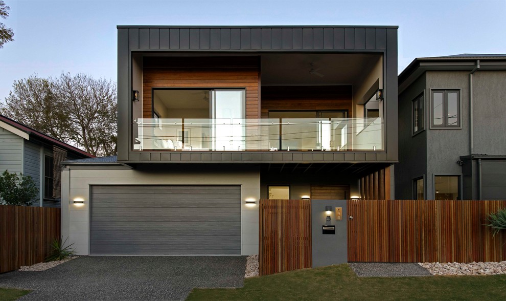 Réalisation d'une façade de maison noire design à un étage avec un revêtement mixte et un toit plat.