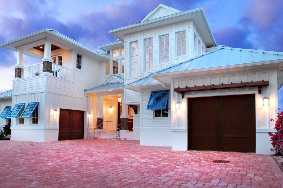 This is an example of an expansive and white nautical two floor render house exterior in Miami with a hip roof.