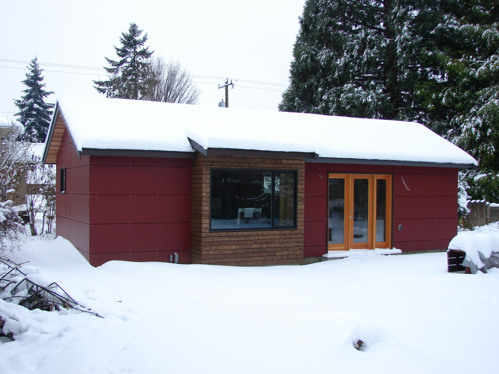 Идея дизайна: маленький, одноэтажный, красный дом в стиле модернизм с облицовкой из ЦСП и двускатной крышей для на участке и в саду