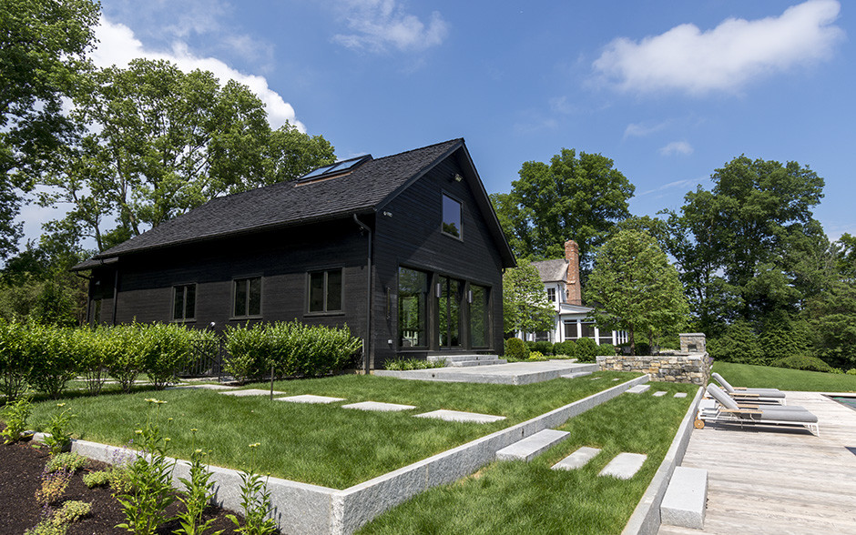 Ejemplo de fachada de casa negra tradicional de tamaño medio de dos plantas con revestimiento de madera