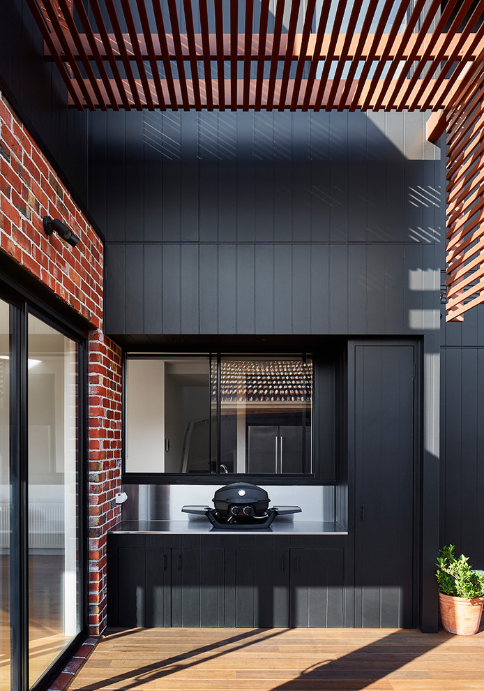 Example of a mid-sized trendy black two-story wood exterior home design in Melbourne with a metal roof