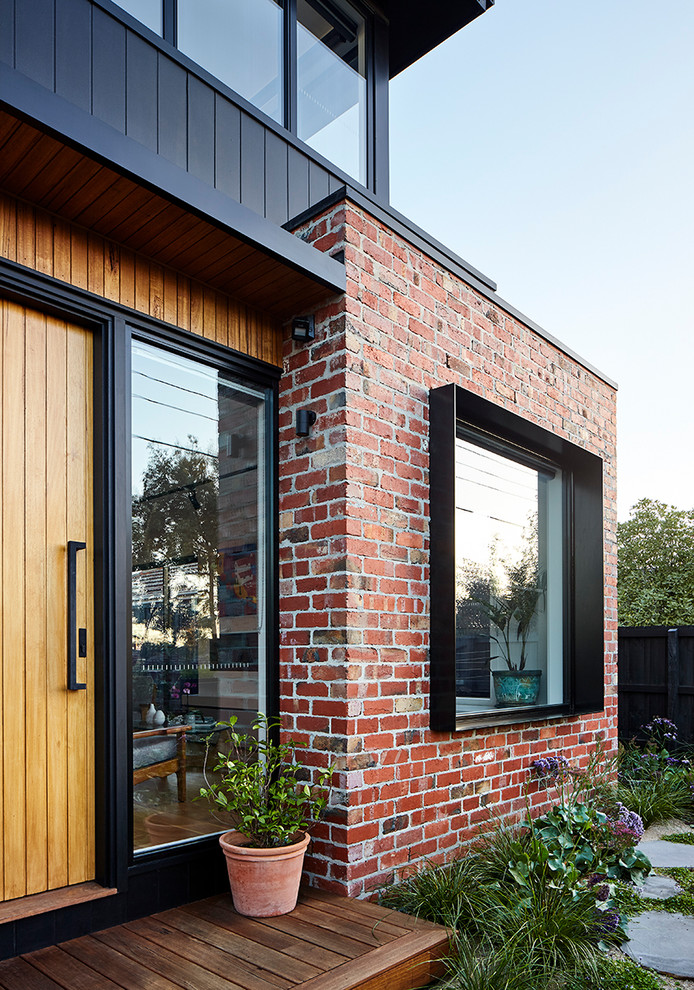 Ejemplo de fachada de casa negra actual de tamaño medio de dos plantas con revestimiento de madera, tejado a dos aguas y tejado de metal