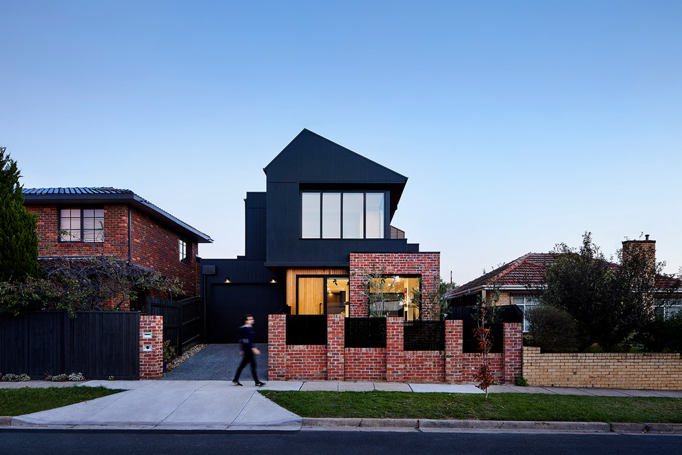 Modelo de fachada de casa negra contemporánea de tamaño medio de dos plantas con revestimiento de madera, tejado a dos aguas y tejado de metal