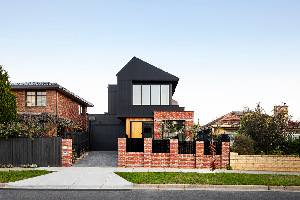 Réalisation d'une façade de maison noire design en bois de taille moyenne et à un étage avec un toit à deux pans et un toit en métal.
