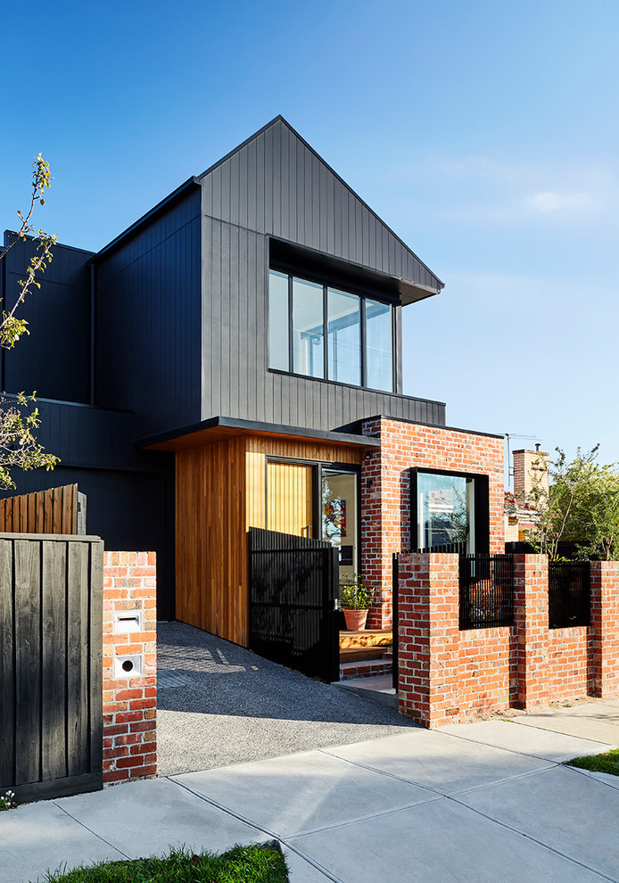 Idéer för ett mellanstort modernt svart hus, med två våningar, sadeltak och tak i metall
