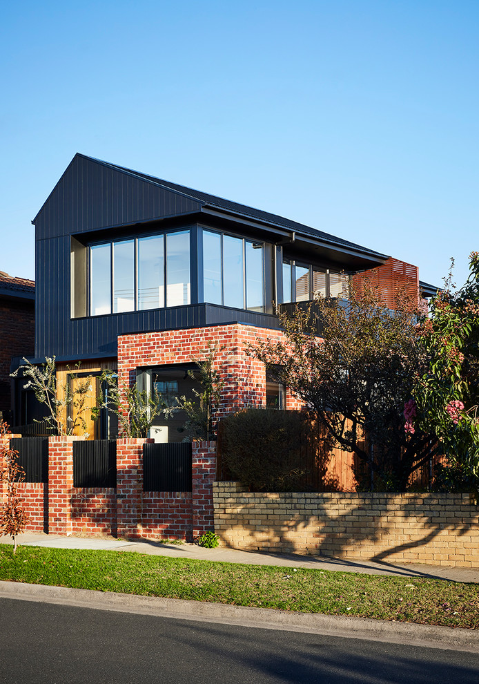 Mittelgroßes, Zweistöckiges Modernes Haus mit schwarzer Fassadenfarbe, Satteldach und Blechdach in Melbourne