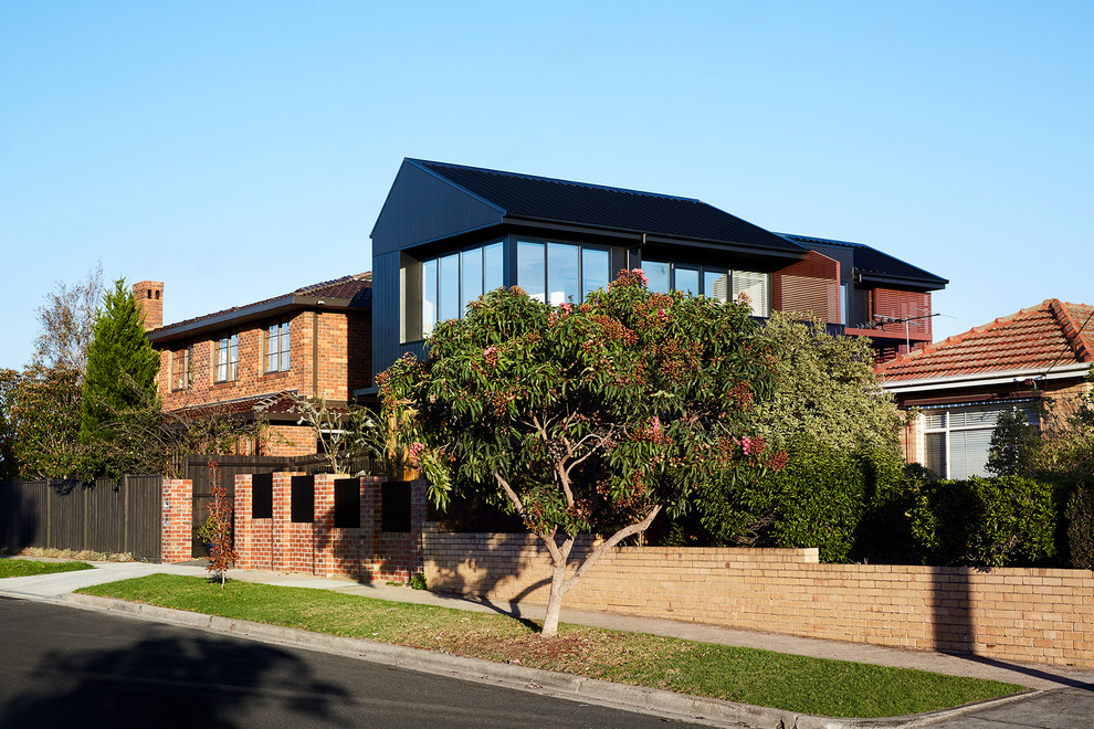 Ejemplo de fachada de casa negra contemporánea de tamaño medio de dos plantas con revestimiento de madera, tejado a dos aguas y tejado de metal