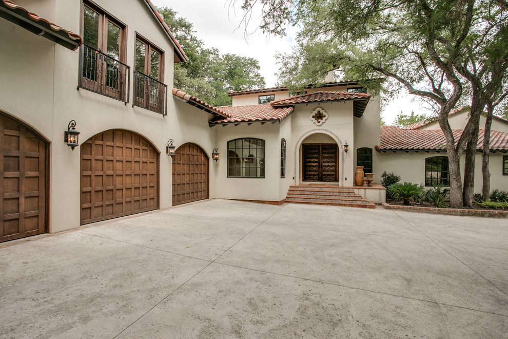 Large tuscan beige two-story stucco exterior home photo in Dallas