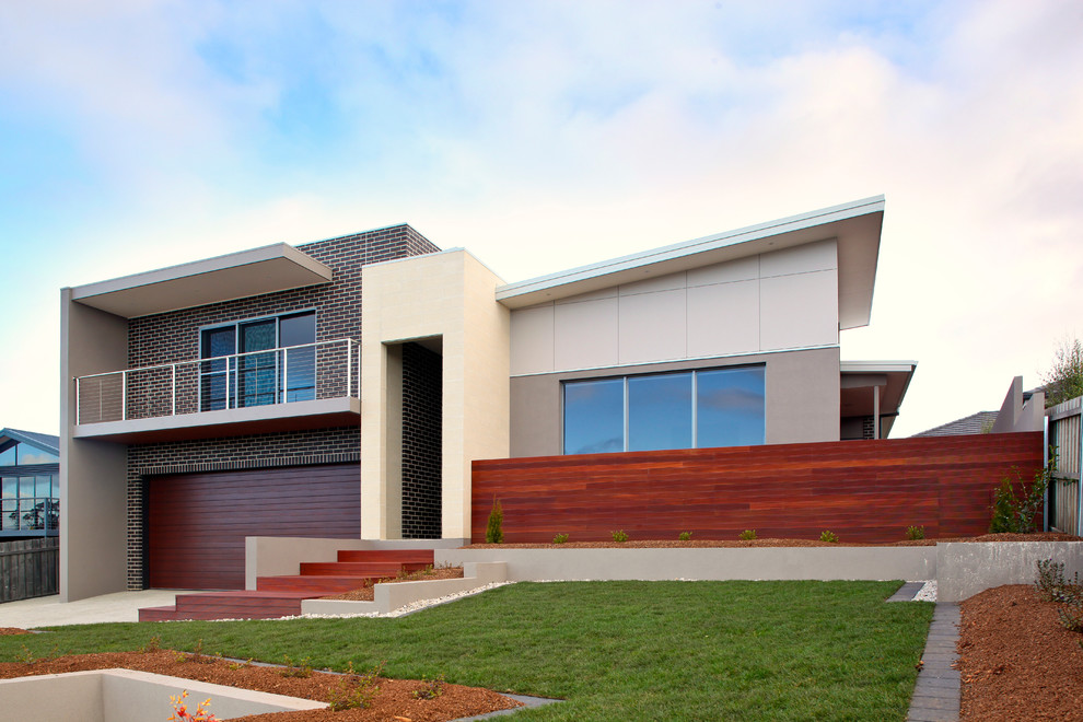 Пример оригинального дизайна: разноцветный частный загородный дом среднего размера в стиле модернизм с разными уровнями, комбинированной облицовкой, плоской крышей и металлической крышей