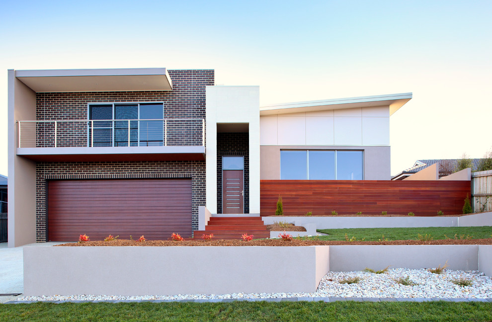 Diseño de fachada de casa multicolor moderna de tamaño medio a niveles con revestimientos combinados, tejado plano y tejado de metal