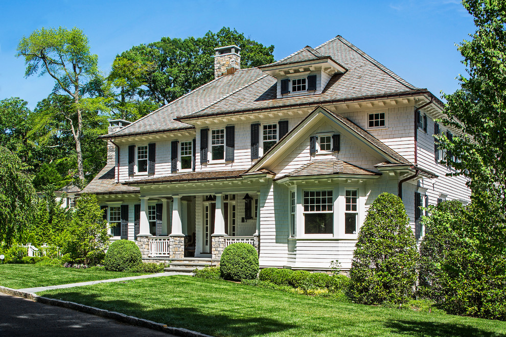 Cette photo montre une grande façade de maison blanche craftsman à un étage avec un revêtement en vinyle et un toit à quatre pans.
