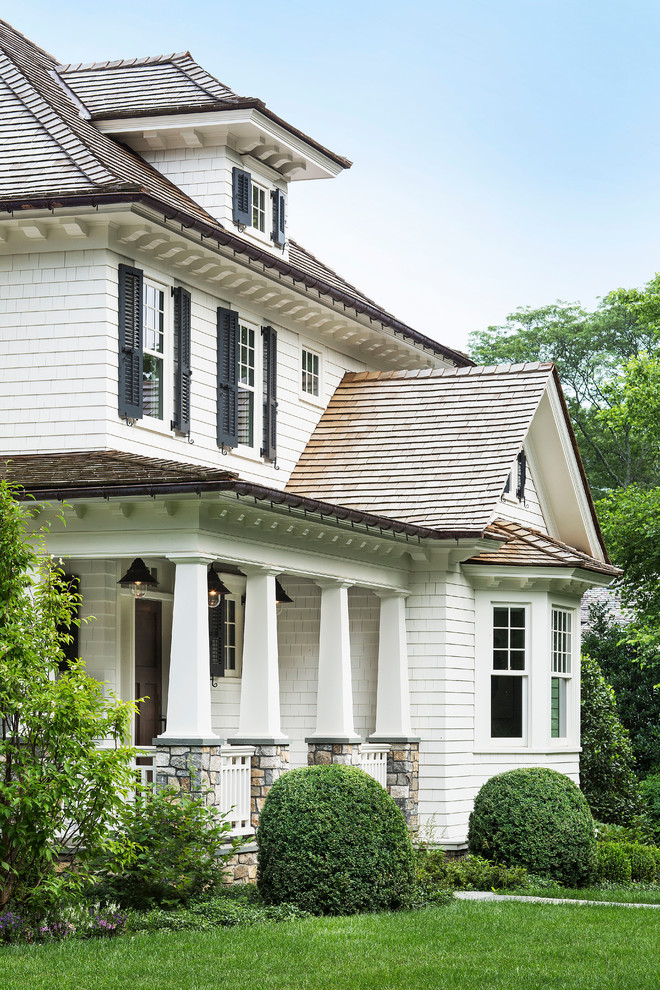 Idee per la facciata di una casa grande bianca american style a due piani con rivestimento in vinile, tetto a padiglione e abbinamento di colori