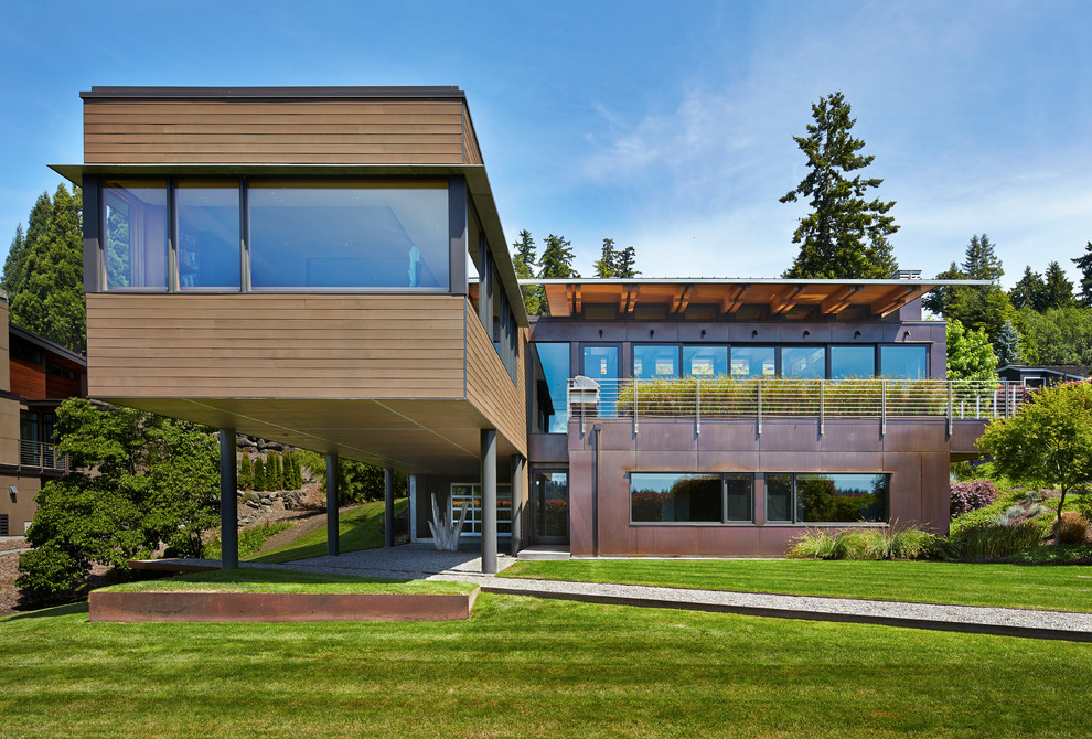 Cette image montre une grande façade de maison marron design à un étage avec un revêtement mixte et un toit plat.