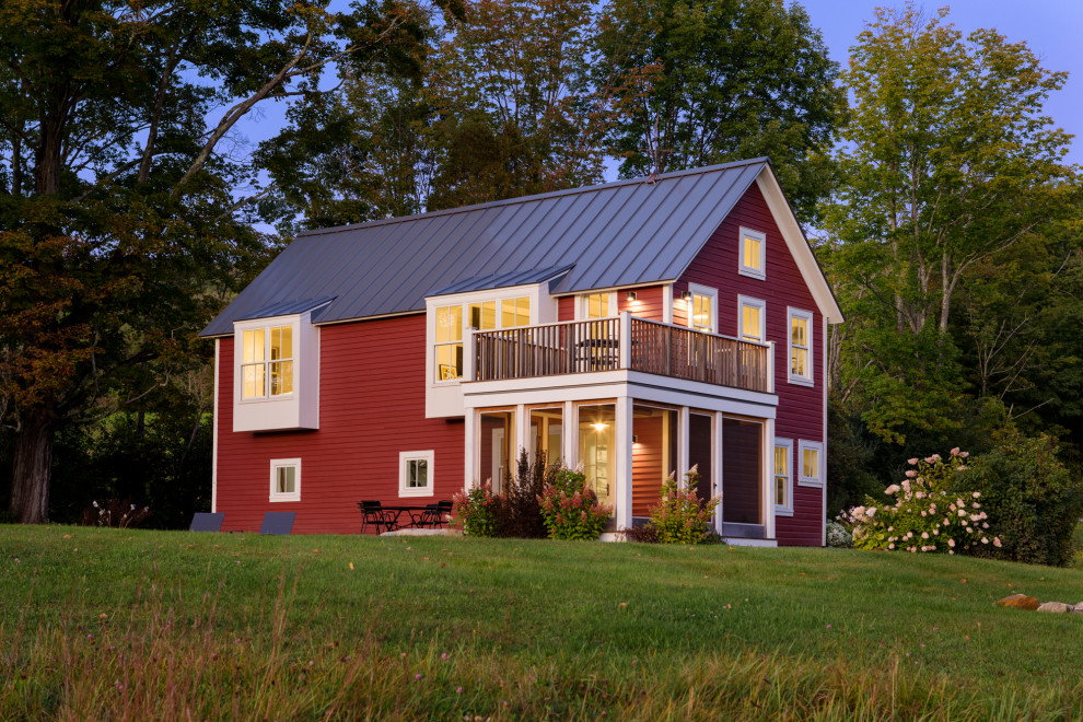 На фото: двухэтажный, деревянный, красный частный загородный дом среднего размера в скандинавском стиле с двускатной крышей, металлической крышей, черной крышей и отделкой планкеном с