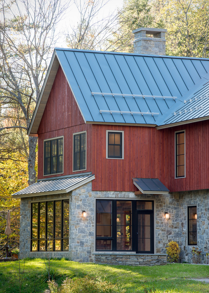 Пример оригинального дизайна: двухэтажный, красный дом среднего размера в стиле кантри с комбинированной облицовкой и двускатной крышей