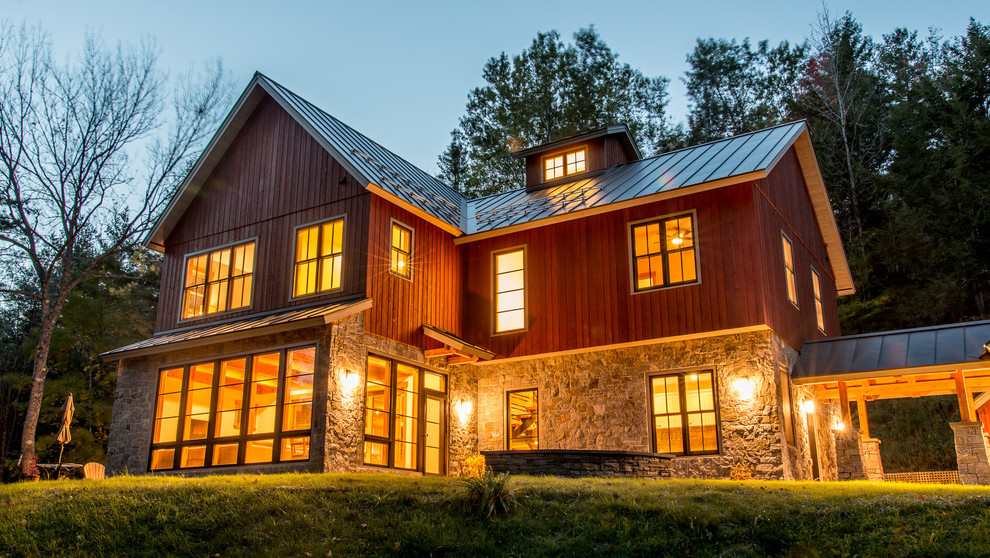 Aménagement d'une façade de maison rouge campagne de taille moyenne et à un étage avec un revêtement mixte et un toit à deux pans.