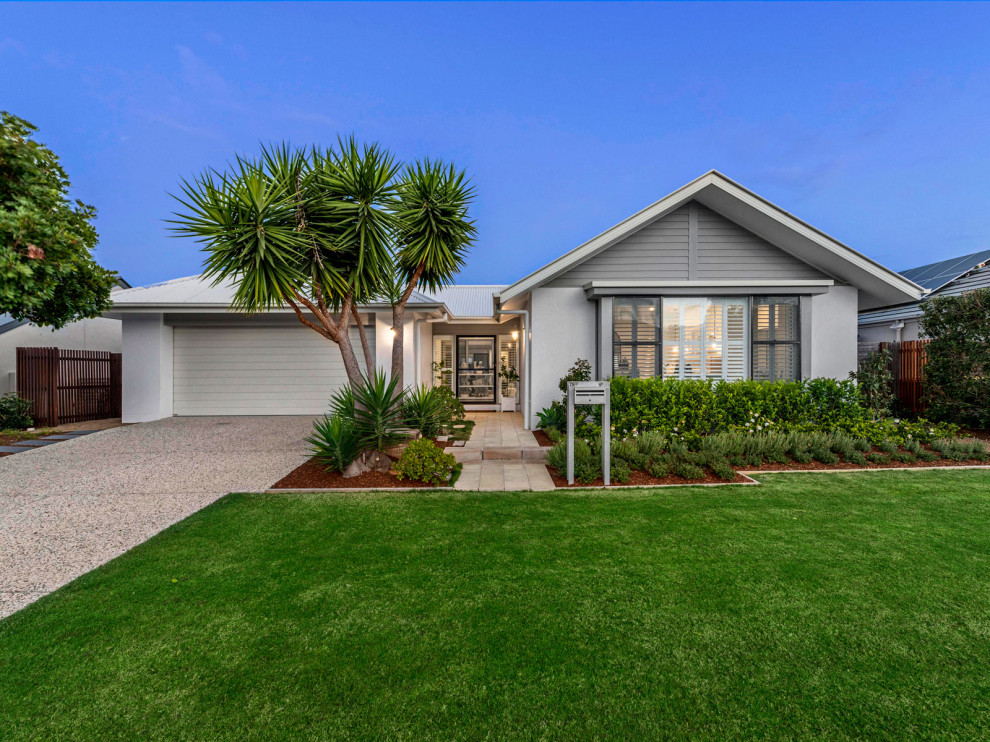 Example of a mid-sized beach style gray one-story mixed siding exterior home design in Brisbane with a metal roof