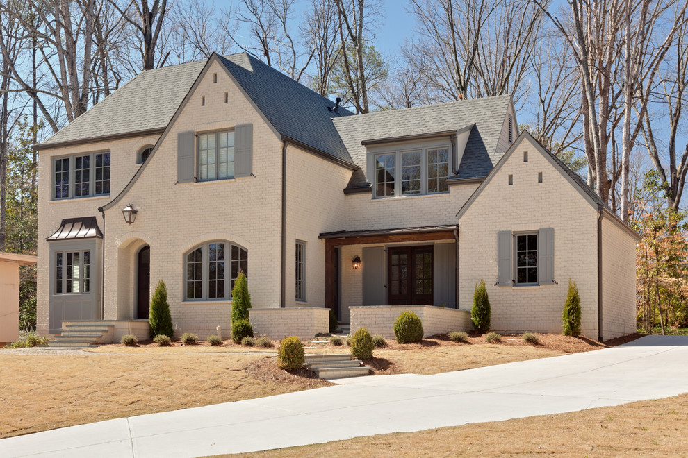 Mid-sized traditional beige two-story brick exterior home idea in Atlanta with a hip roof