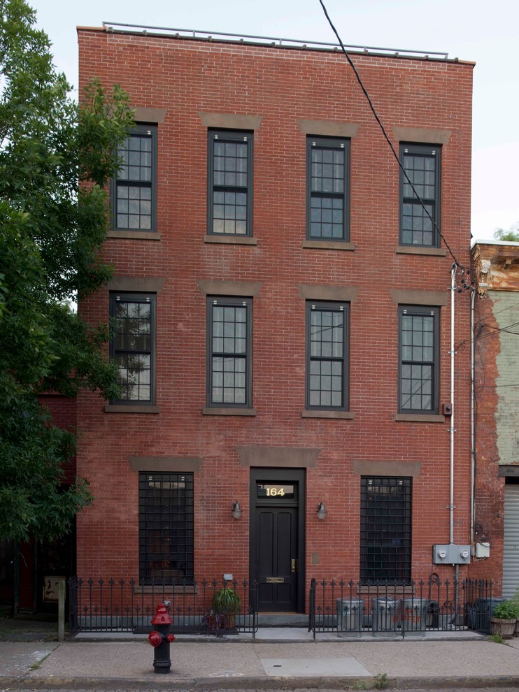Imagen de fachada clásica de tres plantas con revestimiento de ladrillo