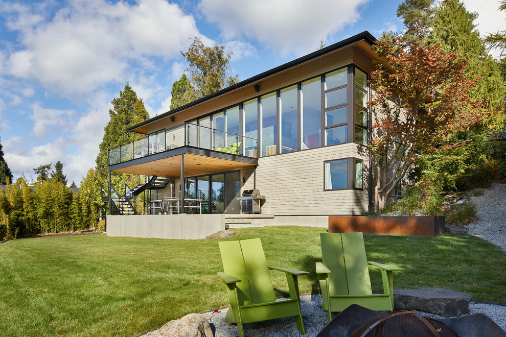 Imagen de fachada gris retro a niveles con revestimiento de madera y tejado a cuatro aguas